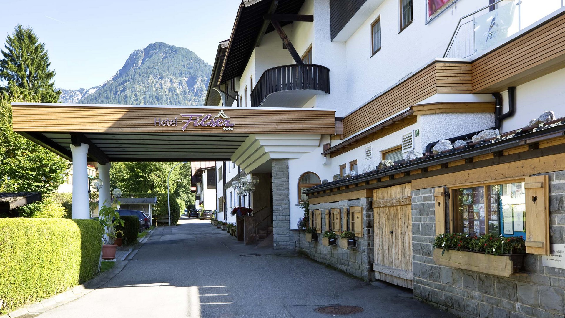 Hotel Filser, your hotel in Oberstdorf Entrance of Hotel Filser with mountain in background and flower decorations